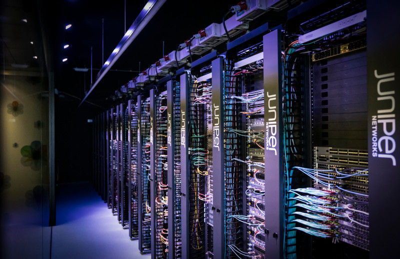 暗いデータセンター/サーバールームとジュニパーのロゴの画像