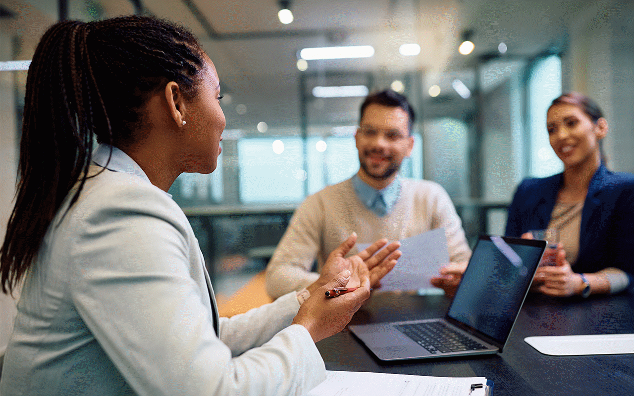 ラップトップを持ってテーブルに座り、議論している人々