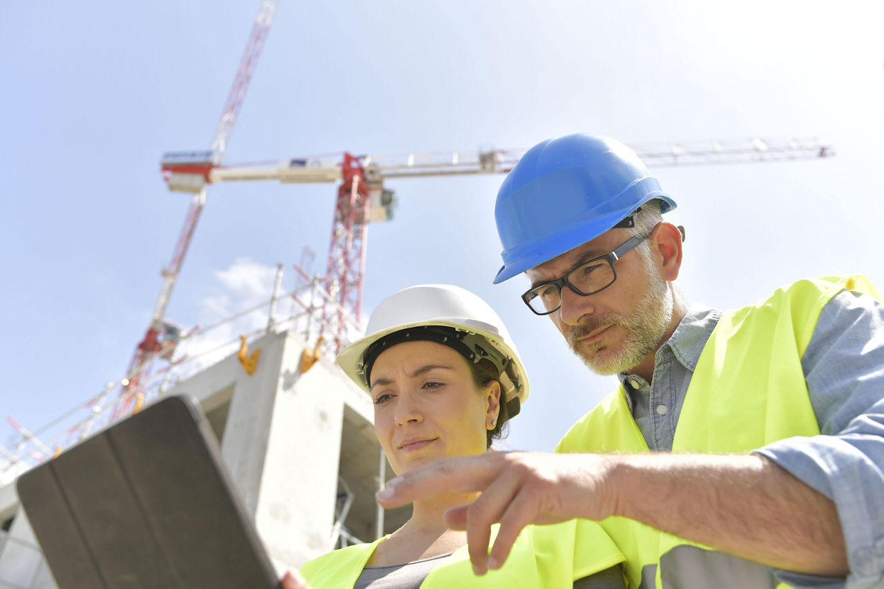 建築管理者と技術者が建築現場で働いている