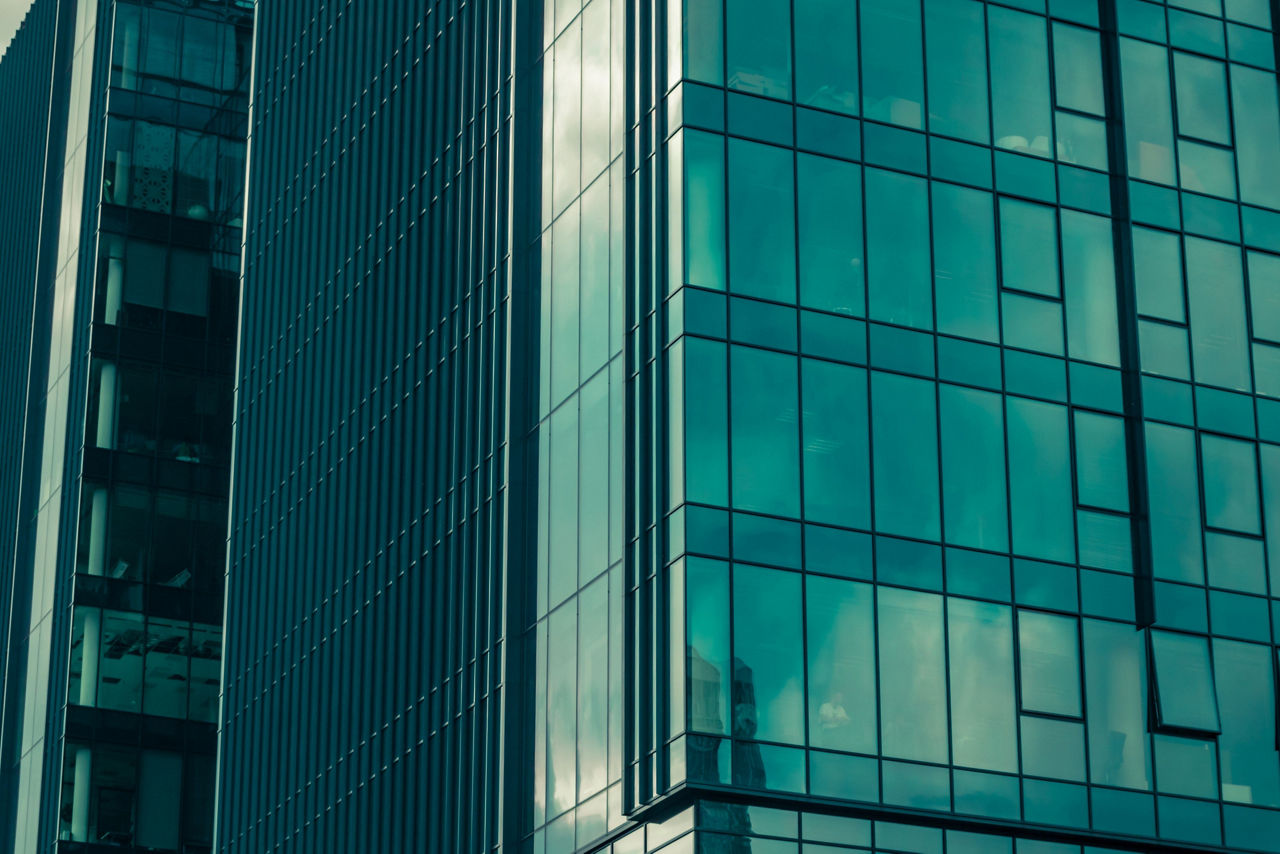 ジュニパーのビルディングブロックソリューションとApstraソフトウェアを表現しているガラス窓のある高層ビルのクローズアップ写真。