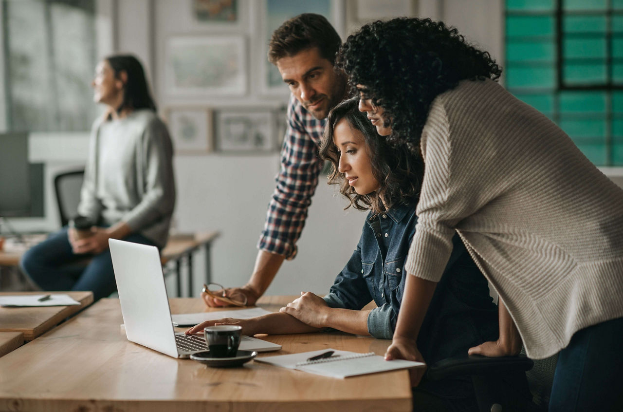 Diverse group of designers working together on an office laptop