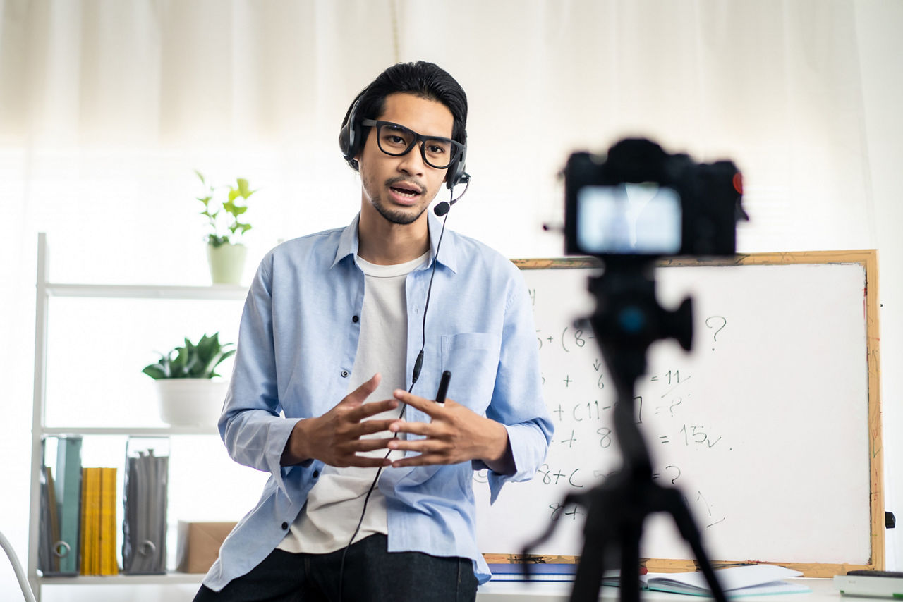 Asian school male teacher working from home teaching online math subject to student studying from home. Man using camera to record his live on internet. Remote education class during covid19 pandemic.