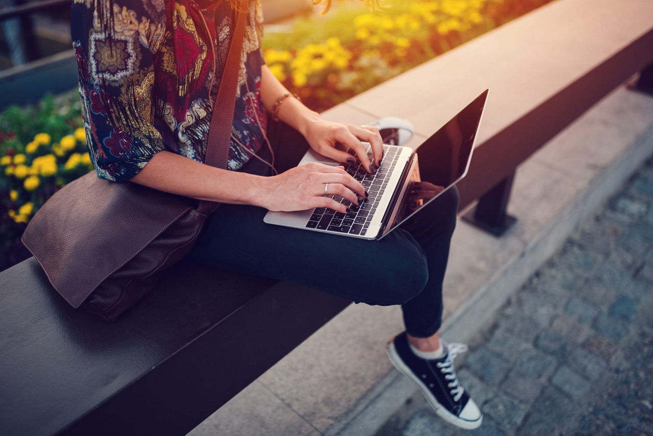 Female student with a laptop on her lap and hands on the keyboard