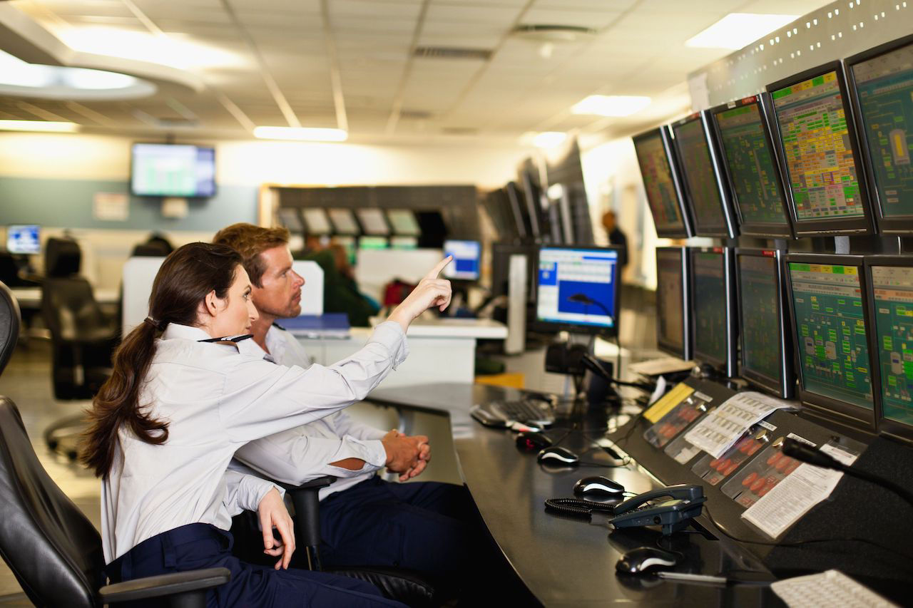 image of two people working in a security control room