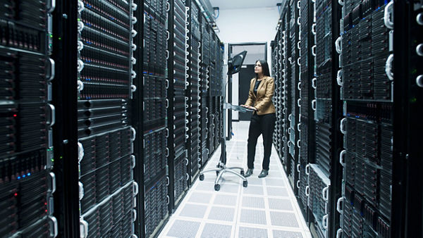 Network professionals working on a mobile laptop standing workstation in a server / data center