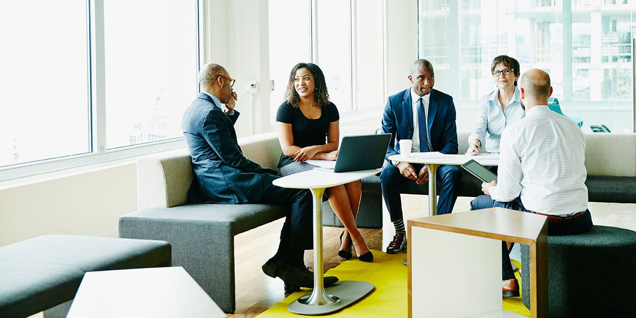 A group of professionals sitting and conversating in a modern office space