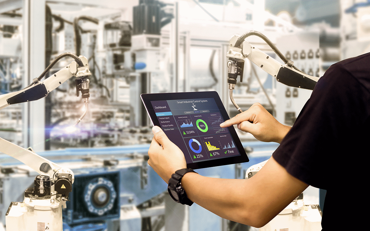 製造ファシリティ内でグラフやチャートを見るためにモバイルタブレットを持っている人