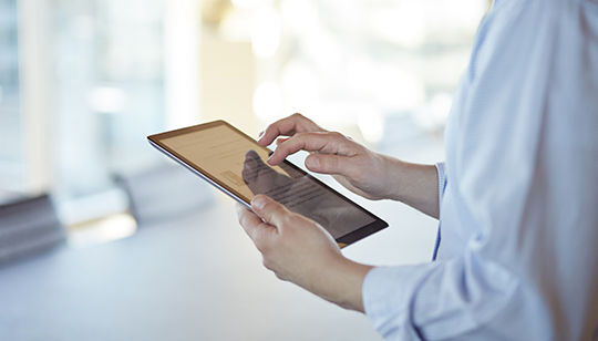 モバイルタブレットを持ってスクロールしている、企業のネットワーキングプロフェッショナル 